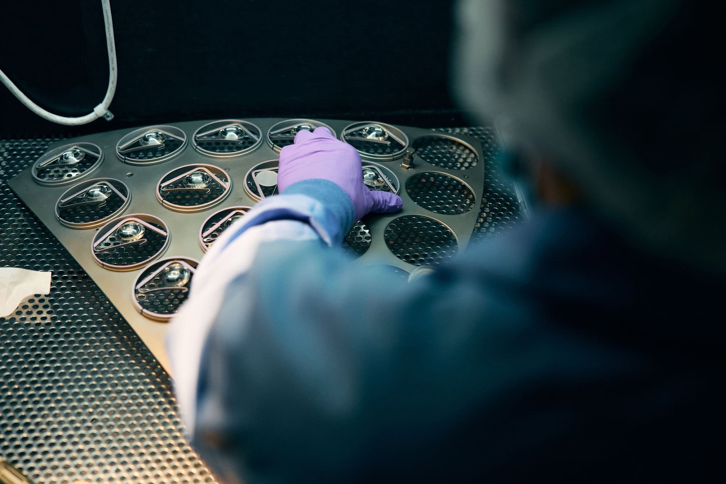 Worker removes metal pieces from machine molds